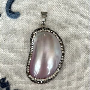 Lovely pendant pearlized shell appears almost lavender black crystal encased